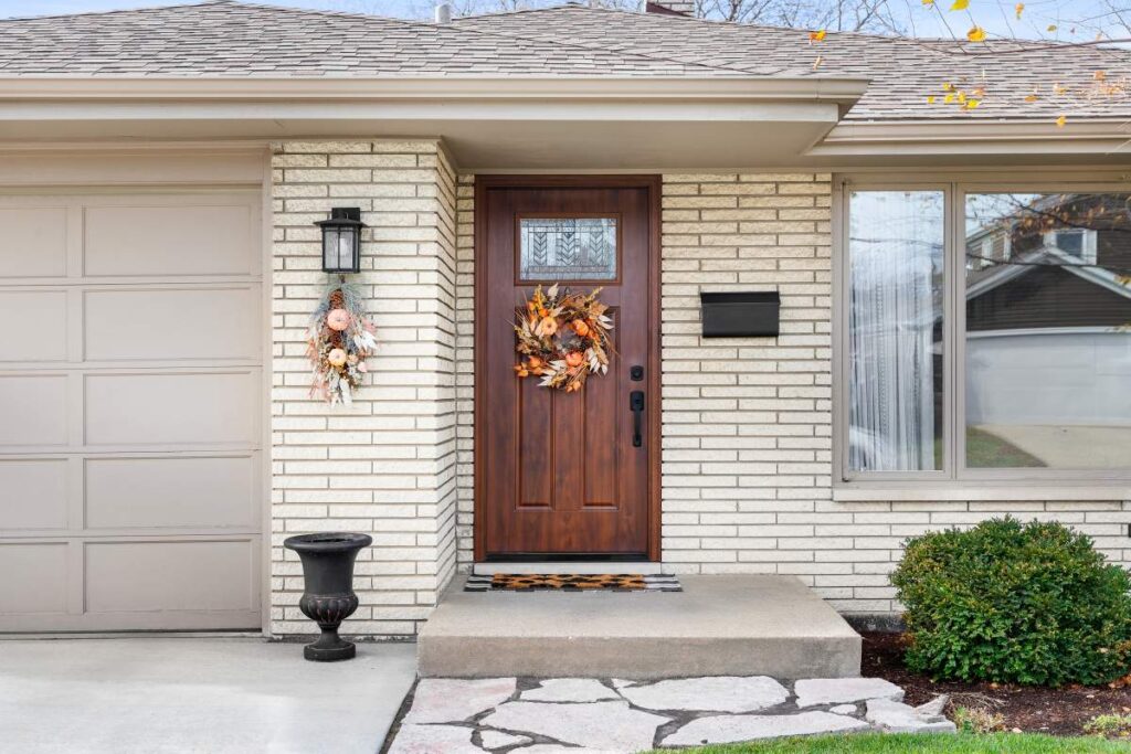 A person standing at a newly installed modern front door with a small glass window, checking the weatherstripping.