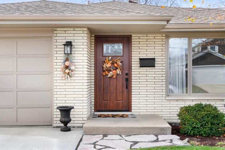 A person standing at a newly installed modern front door with a small glass window, checking the weatherstripping.